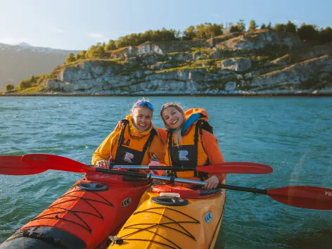 Two girls kayak padling in the Tromso region