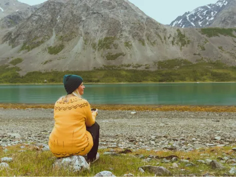 Woman enjoying peace and quiet next to lake in Lyngen