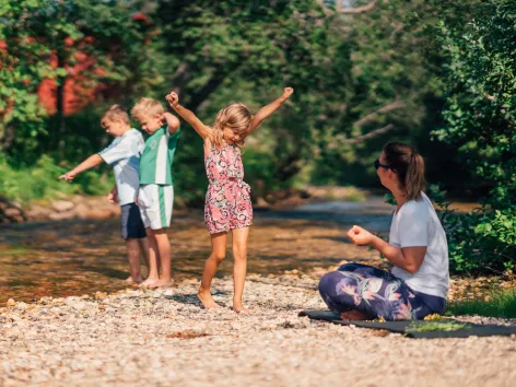 Familie leker ved elven ved Tromsø camping