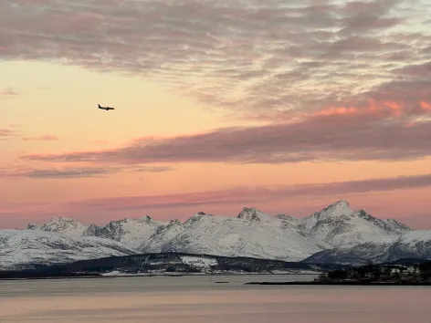 An airplane flying over snowy mountains.