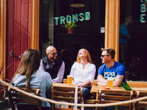 Venner nyter en drink i Tromsø sentrum