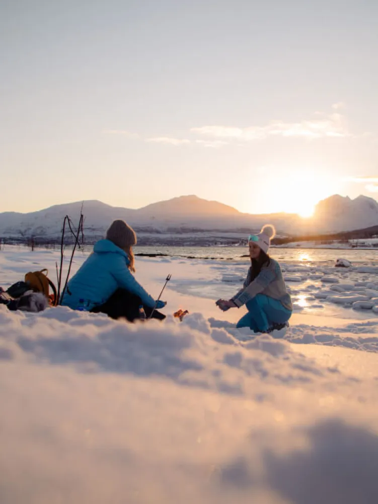 Two girls having a rest in the snow in the Tromso region