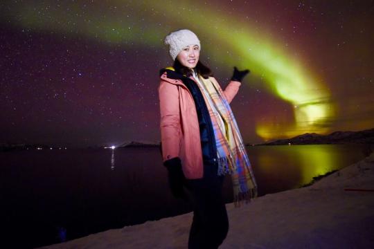 A guest standing under the northern lights