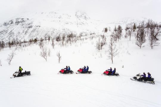 Snøscooter i arktisk vinterlandskap i Tromsøregionen