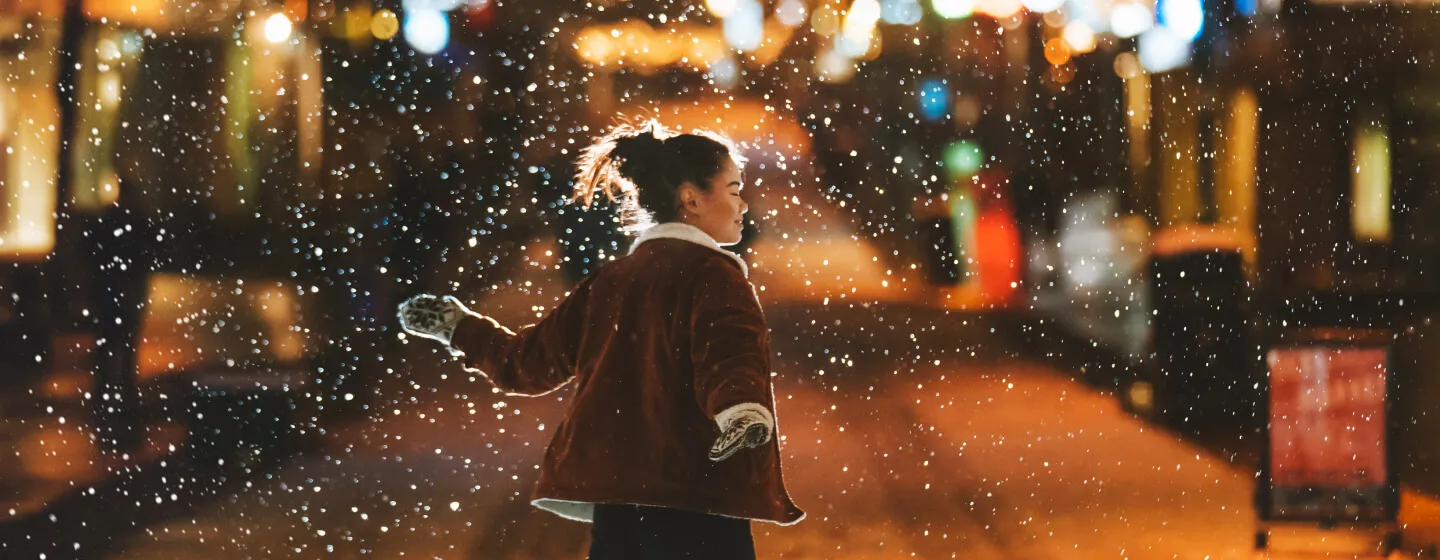 Girl enjoying snowing weather in Tromsø during Christmas