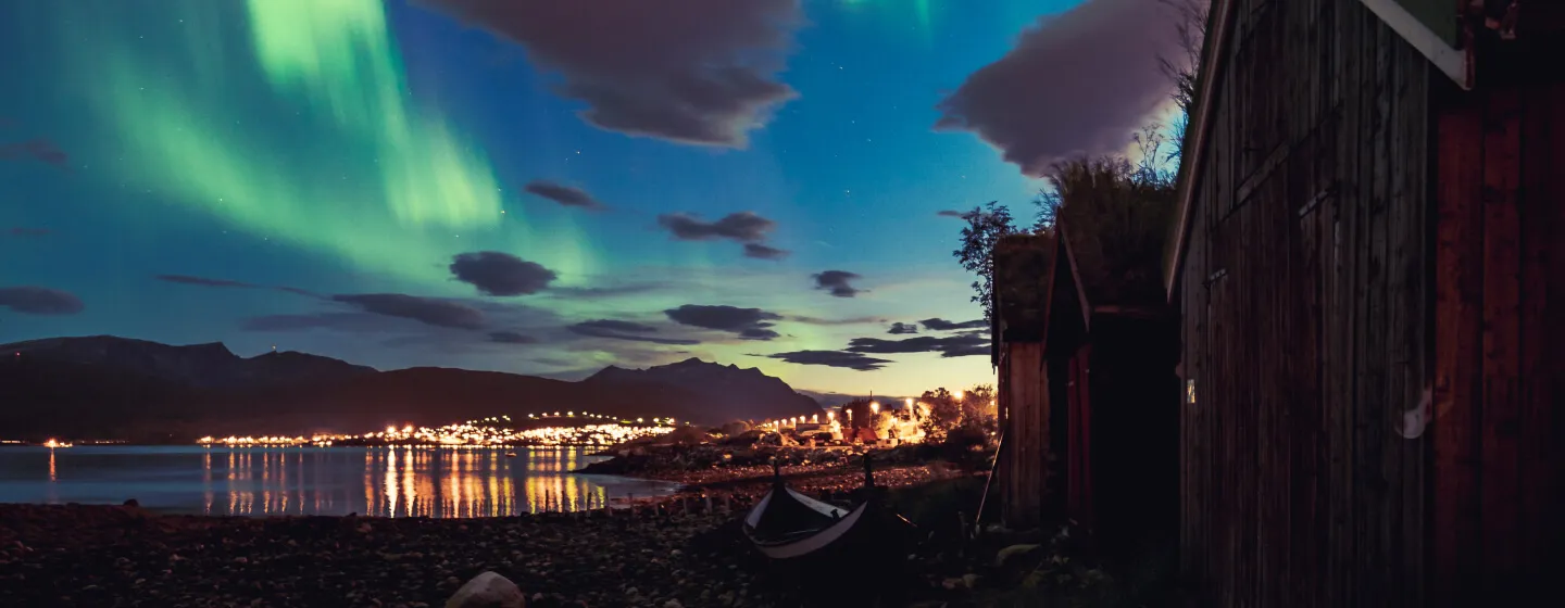 Nordlys over Tromsø med utsikt fra strandkanten