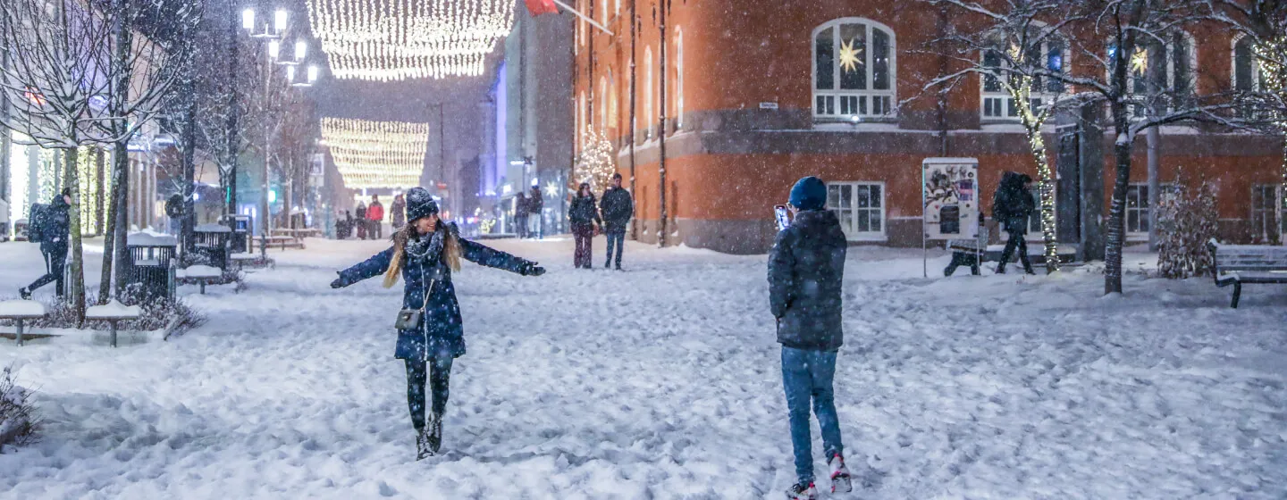 Two people playing in the snow in the main street of Tromsø