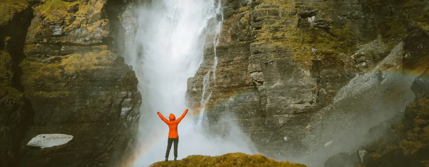 Person standing in front of a waterfall