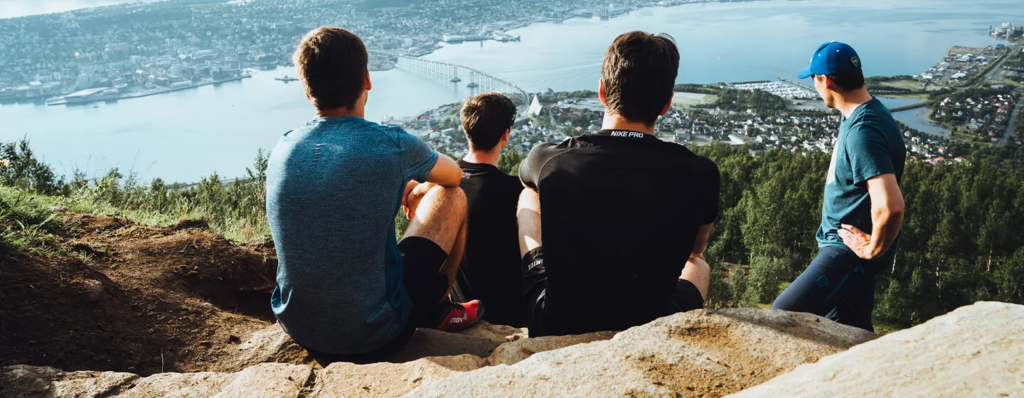 Persons sitting on the Sherpa stairs admiring the view of Tromsø