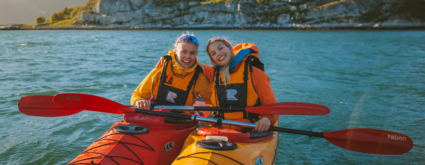 Two girls kayak padling in the Tromso region