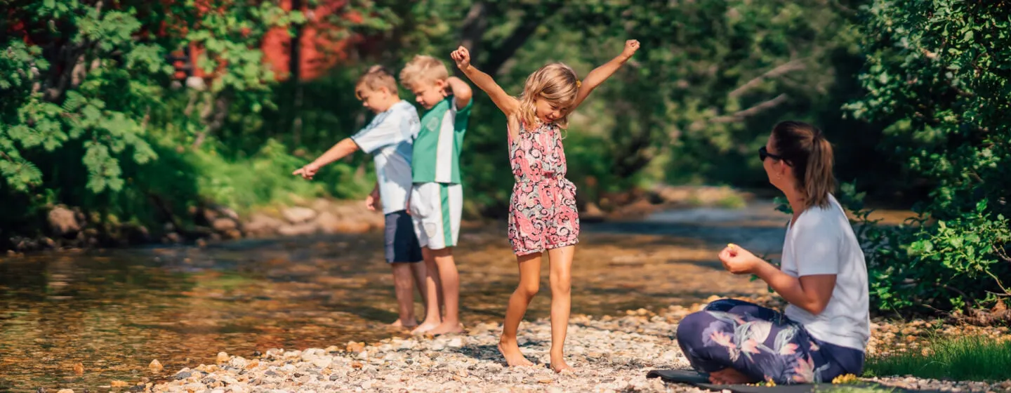 Familie leker ved elven ved Tromsø camping