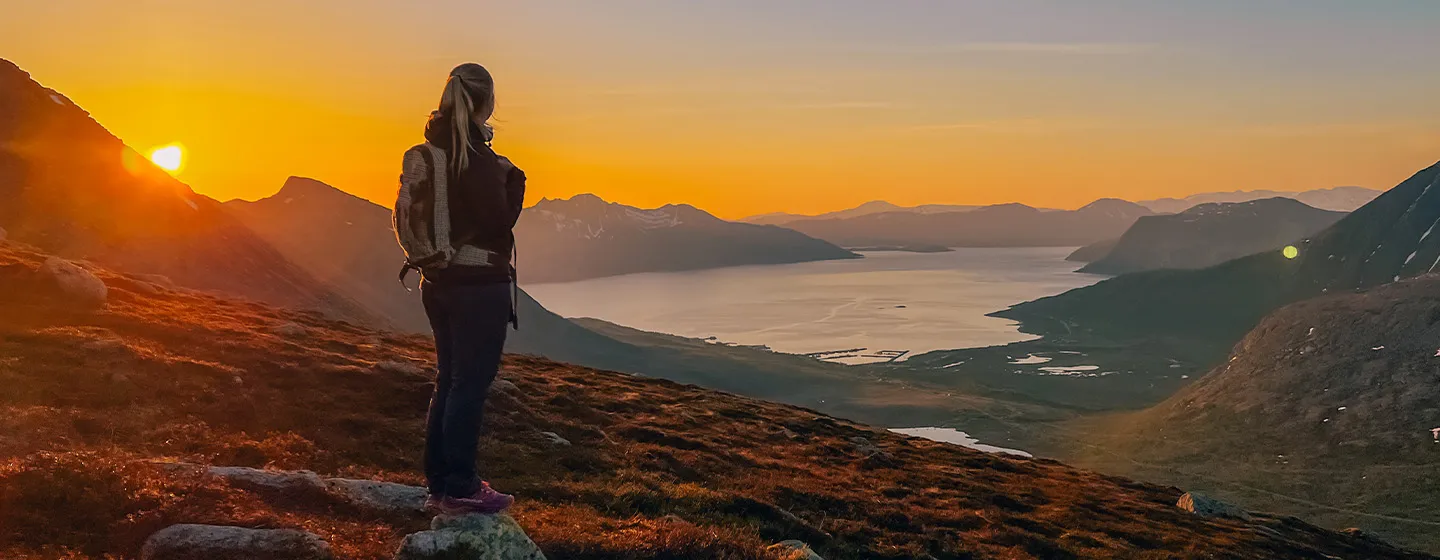 Woman enjoying the midnight sun and view from Kvaløya 